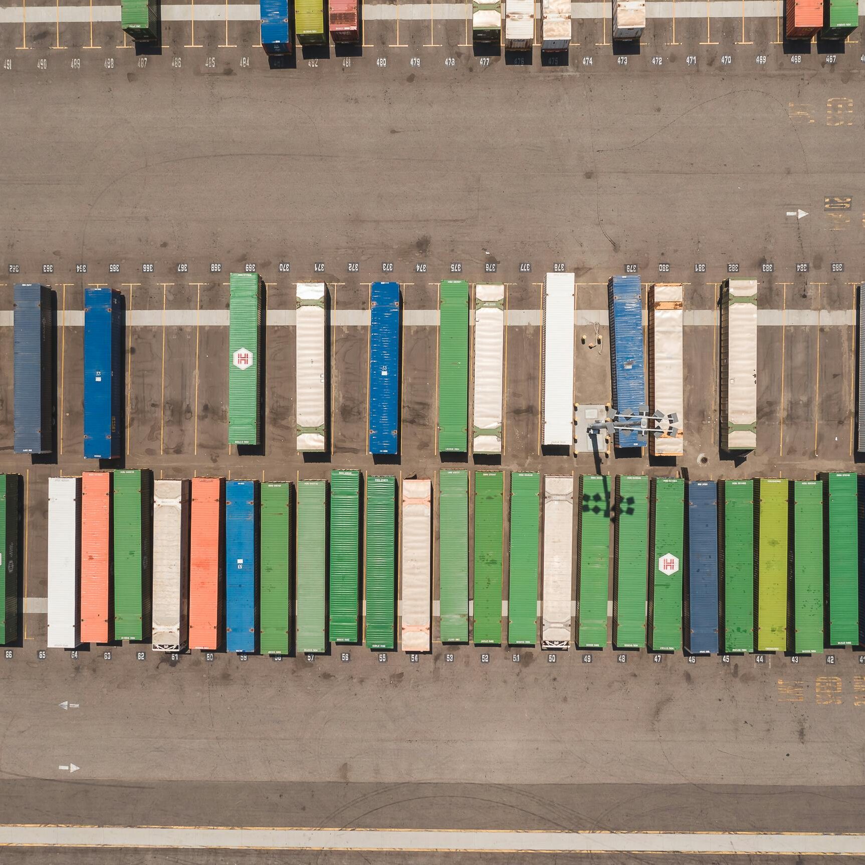 Top view of neatly arranged cargo containers in a shipping port, highlighting logistics and global trade.